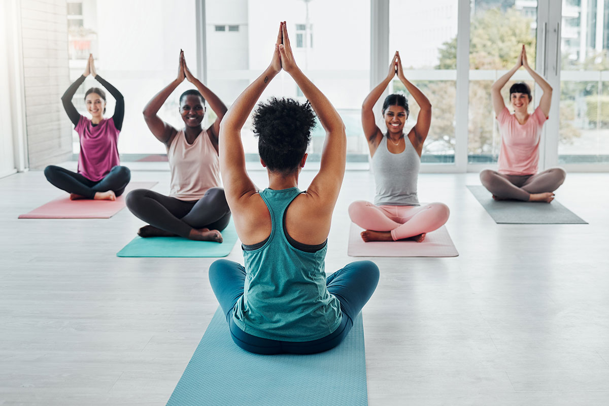 Small-group Pilates class moving together in a bright studio